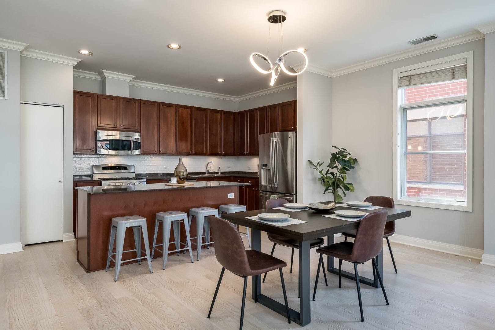 550 West Fulton Street, Unit 301 Chicago, IL 60661 - Photo 11 of 26 a kitchen with granite countertop a table chairs microwave and cabinets