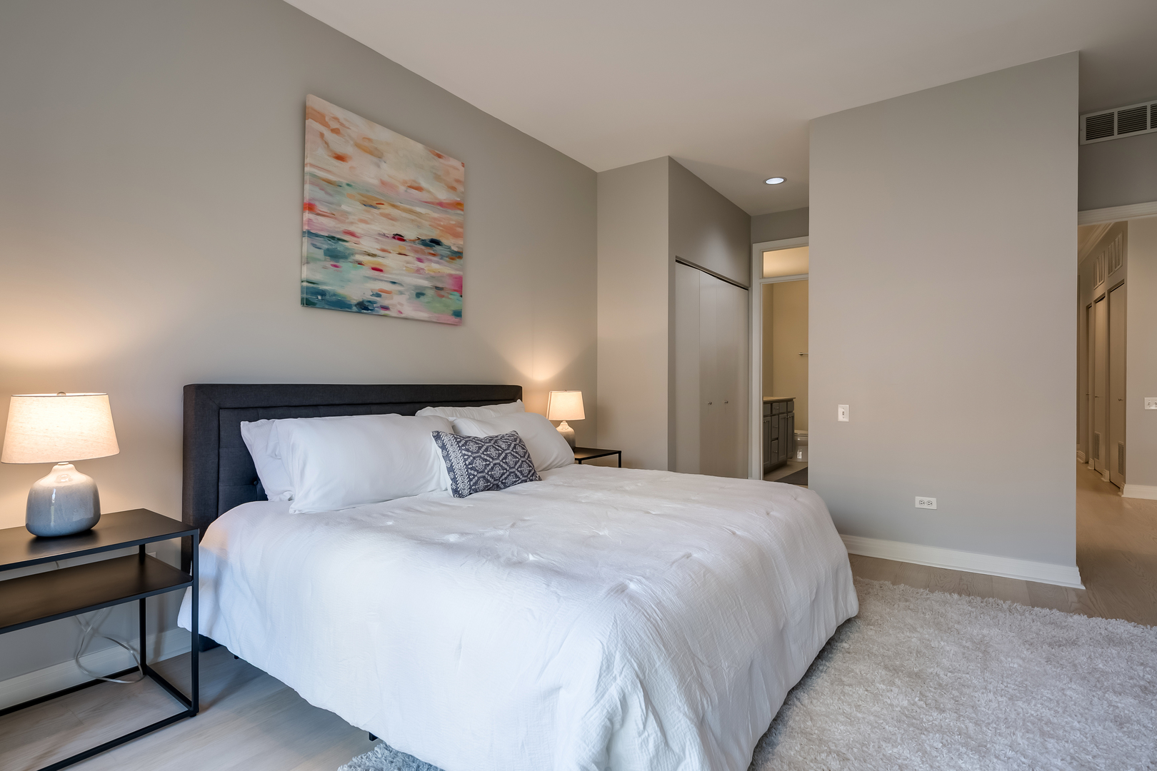 550 West Fulton Street, Unit 301 Chicago, IL 60661 - Photo 13 of 26 a bedroom with a bed and a lamp on table
