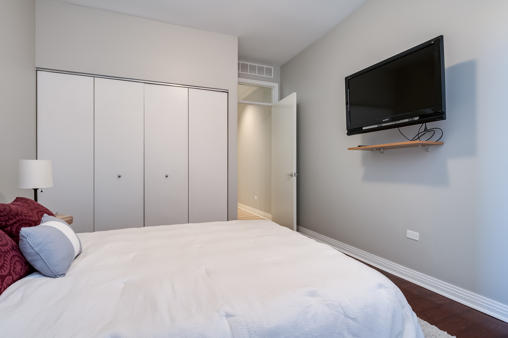 550 West Fulton Street, Unit 301 Chicago, IL 60661 - Photo 18 of 26 a bedroom with a bed and a flat tv screen on wall