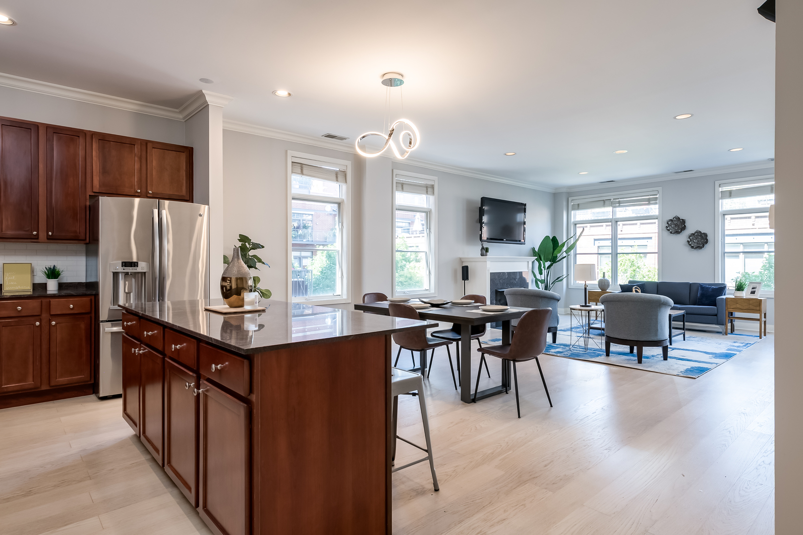 550 West Fulton Street, Unit 301 Chicago, IL 60661 - Photo 3 of 26 a kitchen with stainless steel appliances kitchen island granite countertop a table chairs sink and refrigerator