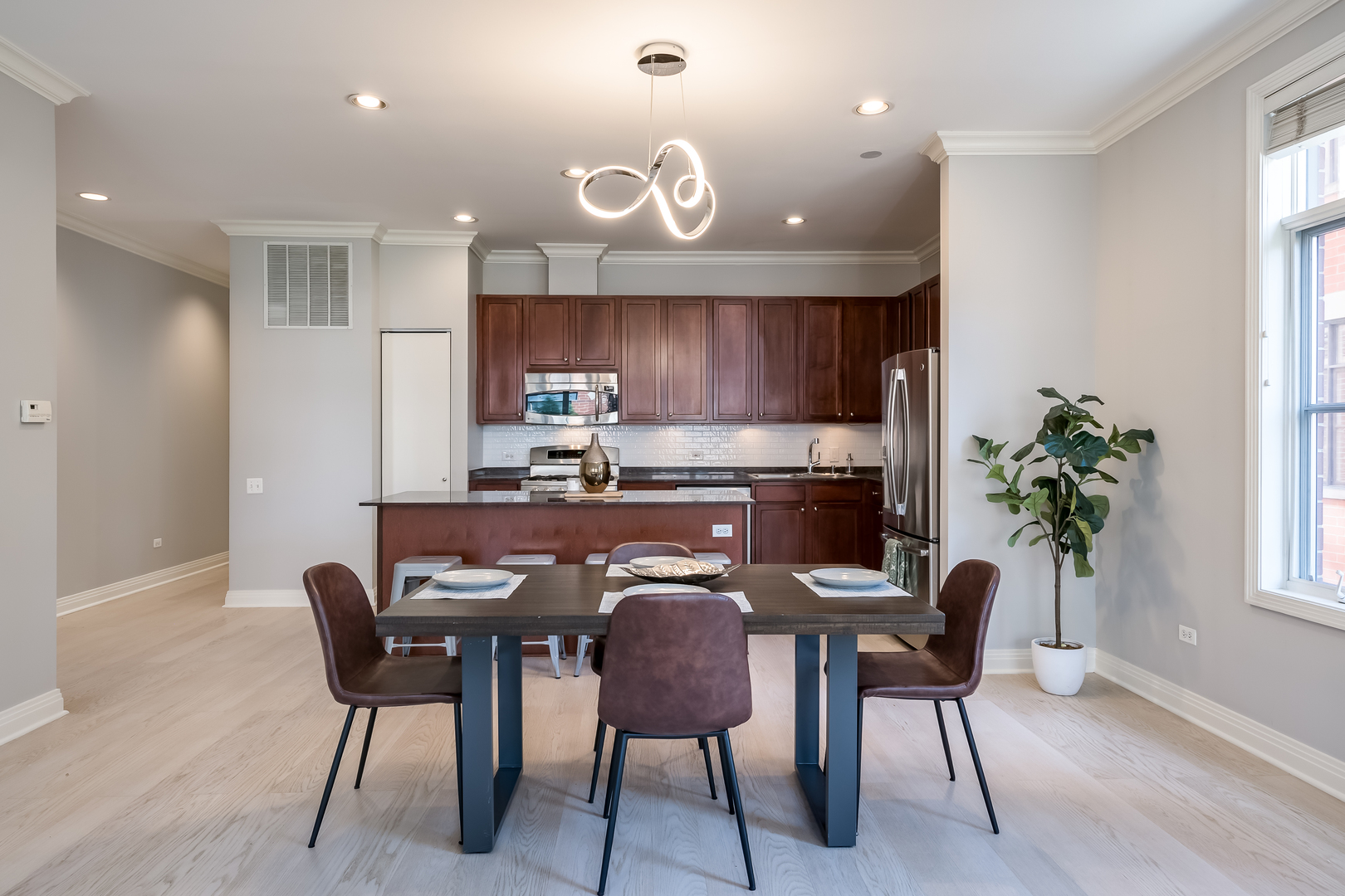 550 West Fulton Street, Unit 301 Chicago, IL 60661 - Photo 9 of 26 a kitchen with granite countertop kitchen island stainless steel appliances a table and chairs in it
