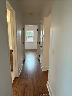 a view of a hallway with wooden floor
