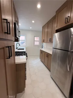 a kitchen with stainless steel appliances granite countertop a refrigerator a stove a sink and a refrigerator