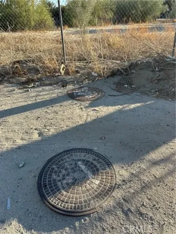 a view of a dry yard with wooden fence
