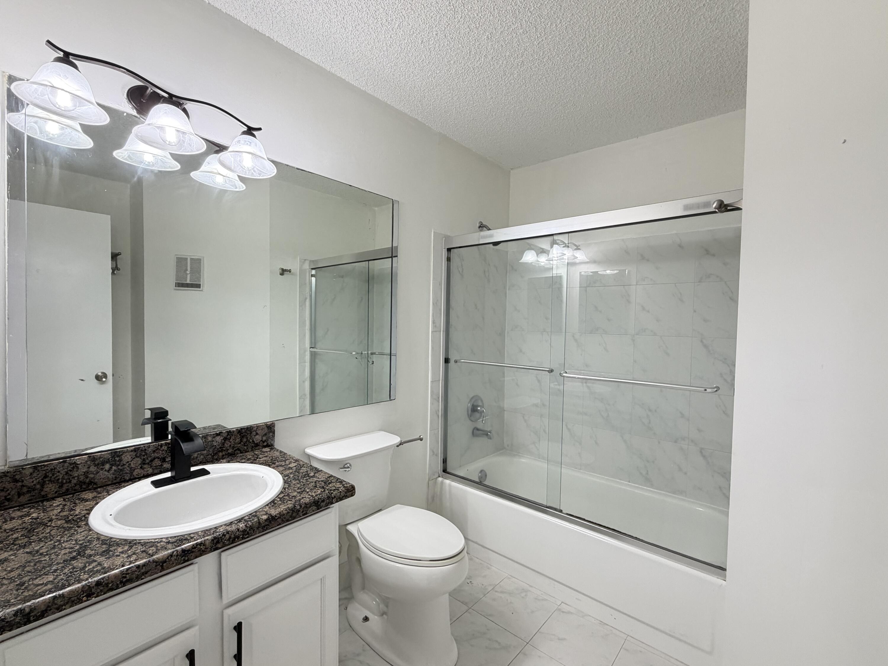 921 Lyons Road, Unit 3205 Coconut Creek, FL 33063 - Photo 13 of 17 a bathroom with a sink a toilet and shower
