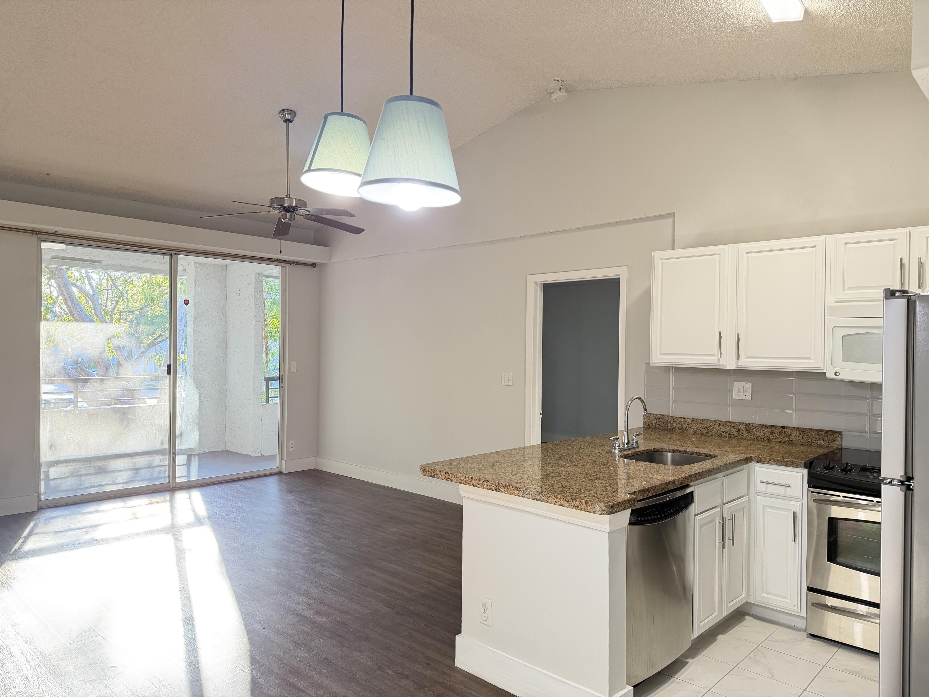 921 Lyons Road, Unit 3205 Coconut Creek, FL 33063 - Photo 2 of 17 a kitchen with stainless steel appliances granite countertop a stove a sink and a refrigerator