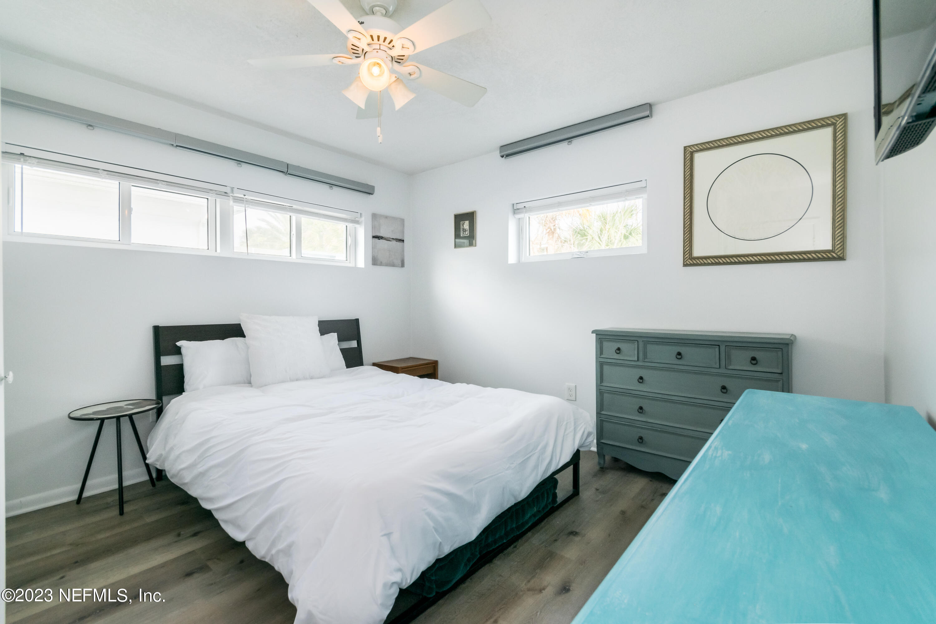 1632 Strand Street Neptune Beach, FL 32266 - Photo 12 of 22 a bedroom with a bed and a chandelier