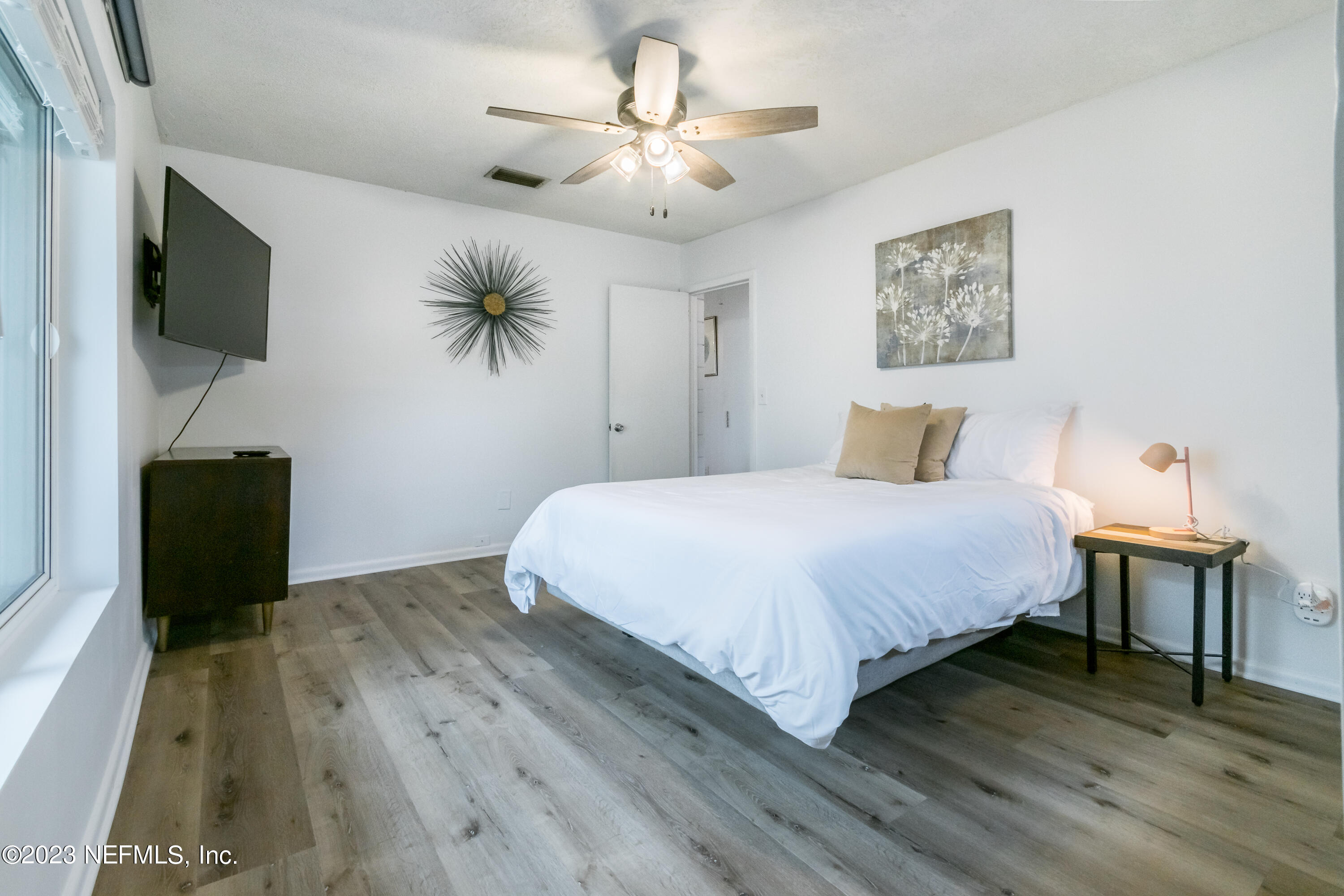 1632 Strand Street Neptune Beach, FL 32266 - Photo 14 of 22 a bedroom with a bed and a flat screen tv