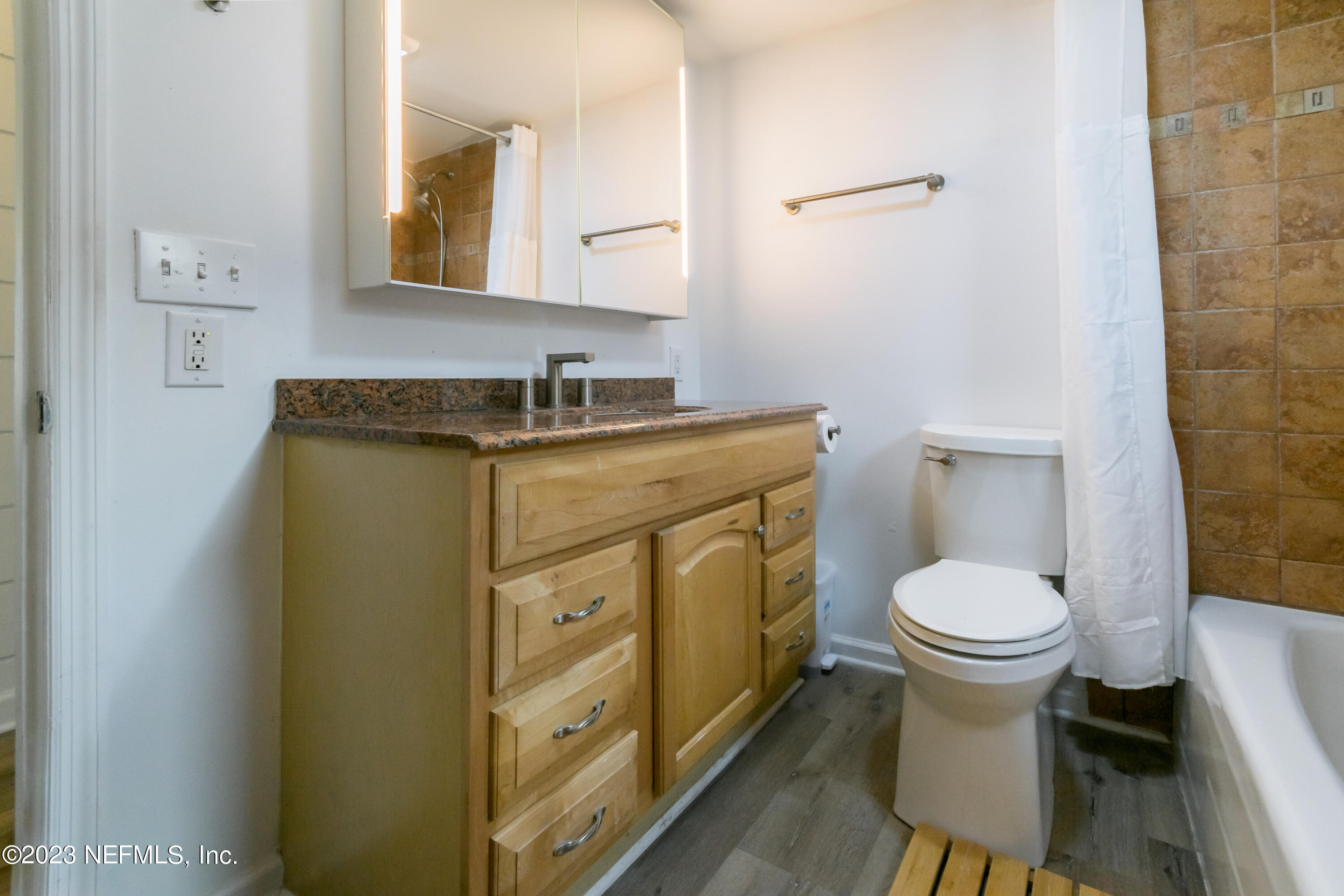 1632 Strand Street Neptune Beach, FL 32266 - Photo 15 of 22 a bathroom with a granite countertop toilet sink and mirror