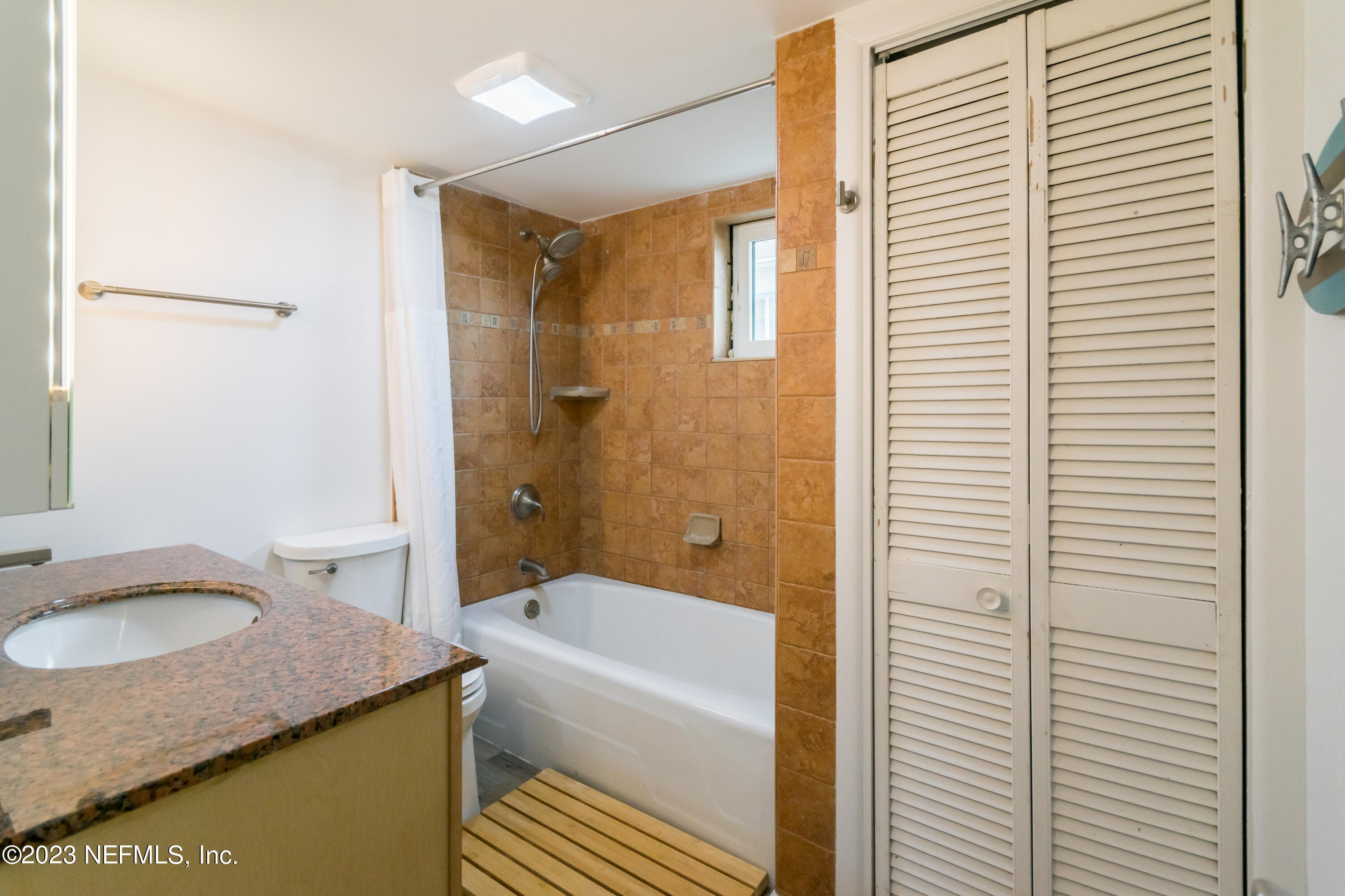 1632 Strand Street Neptune Beach, FL 32266 - Photo 16 of 22 a bathroom with a granite countertop sink and a mirror