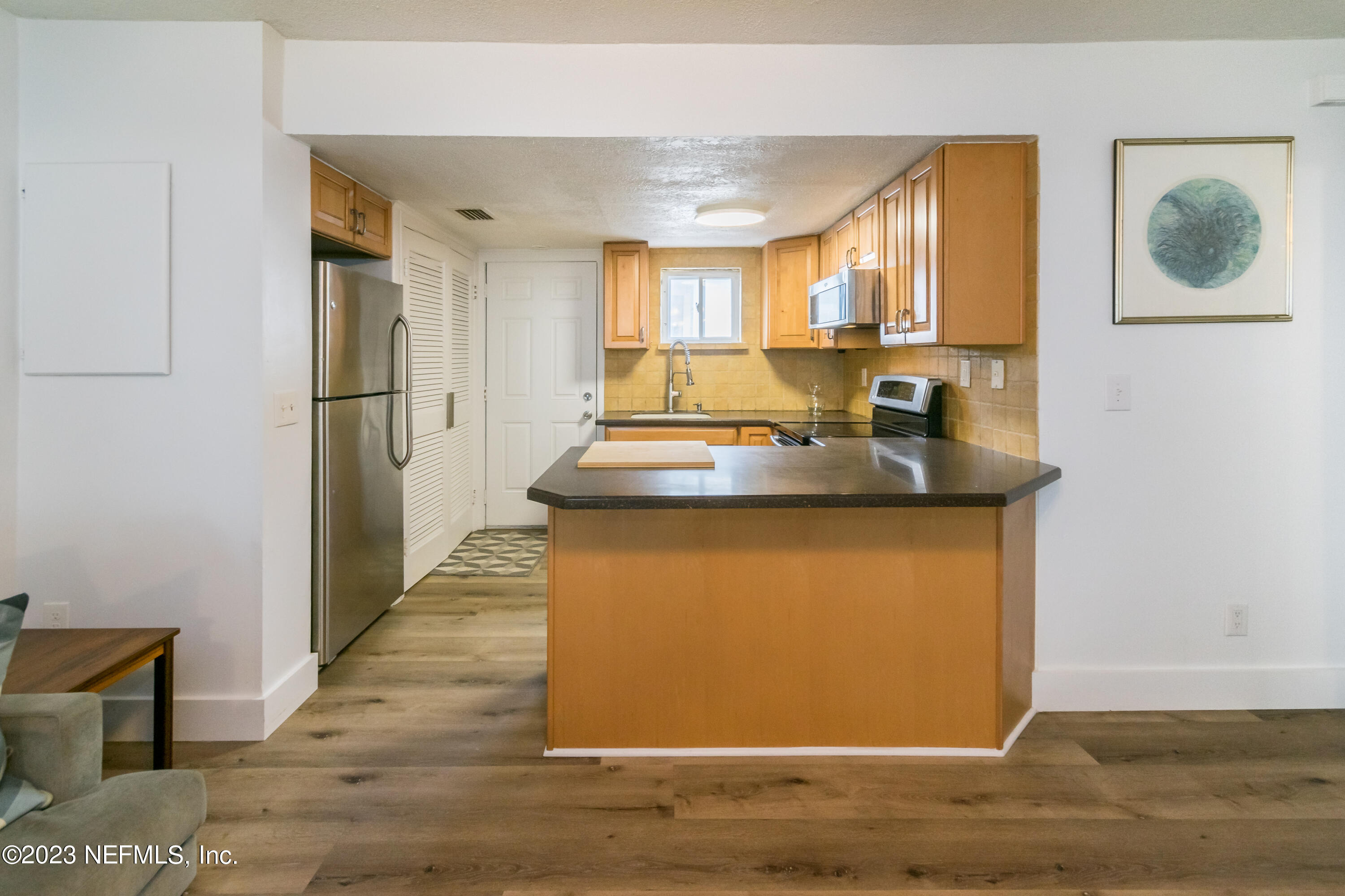 1632 Strand Street Neptune Beach, FL 32266 - Photo 7 of 22 a view of a kitchen with kitchen island a counter top space and wooden floor