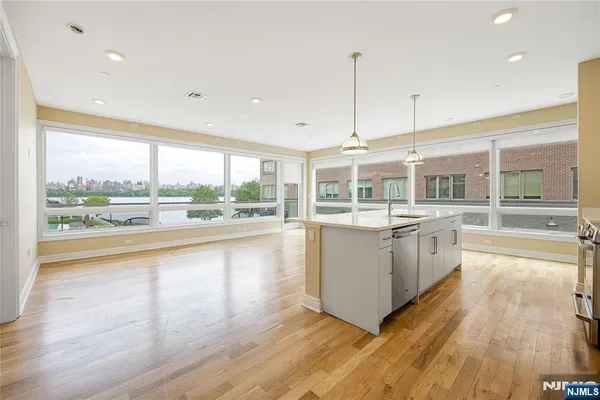 a open kitchen with stainless steel appliances granite countertop a stove and wooden floor