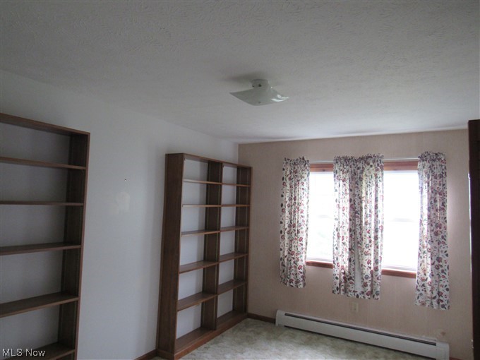 2189 Sentinel Road Dorset, OH 44032 - Photo 15 of 28 Empty room featuring light carpet, baseboard heating, and a textured ceiling