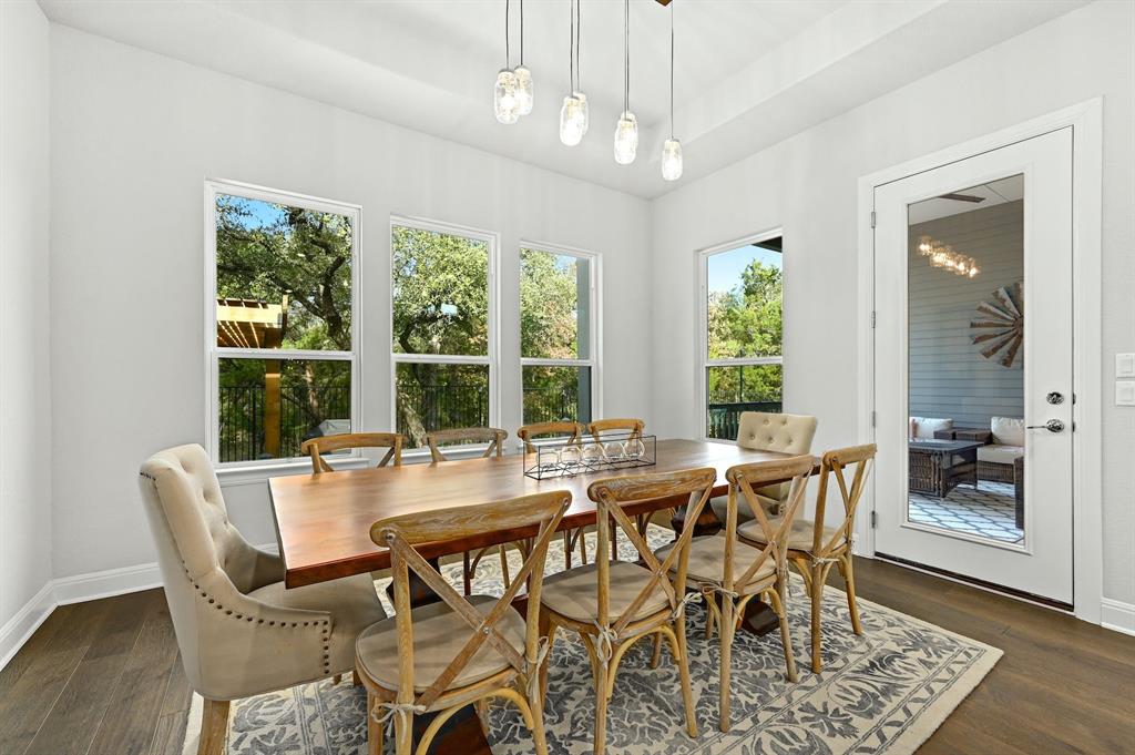 629 Germander Road Leander, TX 78641 - Photo 11 of 32 Natural light floods this inviting dining space, featuring high ceilings and dark hardwood floors.