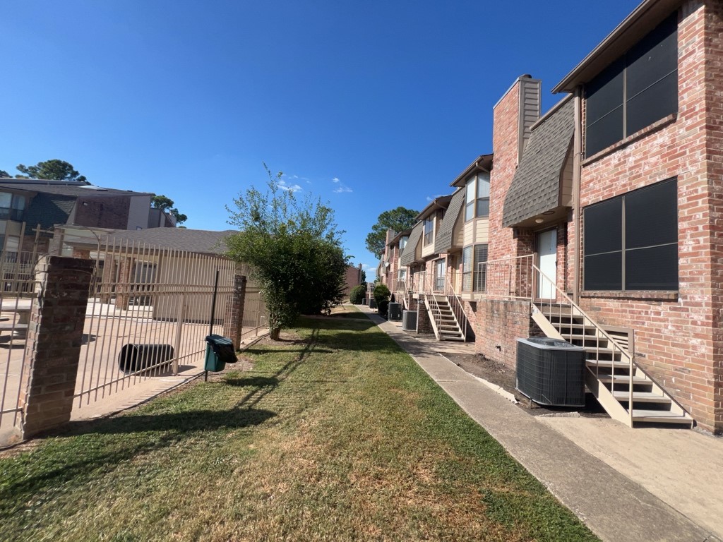 1919 Place Rebecca Lane, Unit H11 Houston, TX 77090 - Photo 16 of 18 a view of a patio with couches and table and chairs with wooden fence and plants