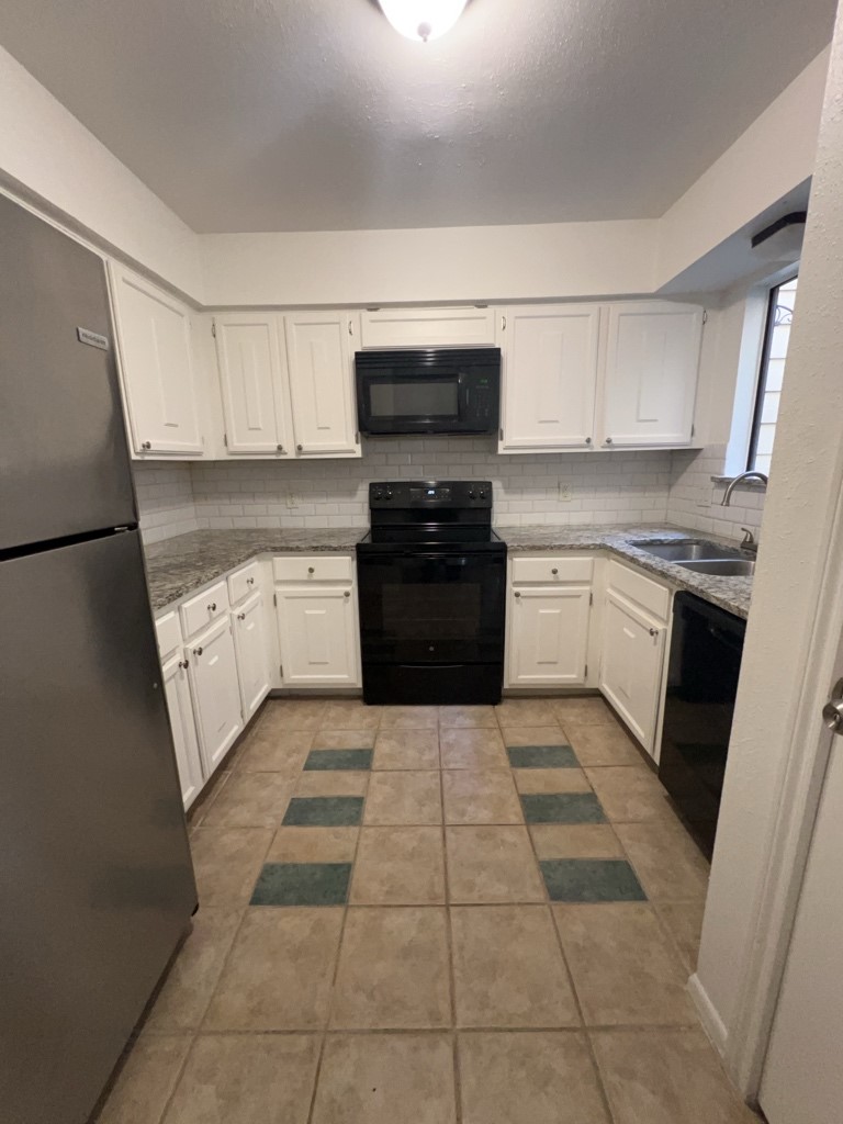 1919 Place Rebecca Lane, Unit H11 Houston, TX 77090 - Photo 6 of 18 a kitchen with a sink a stove top oven and cabinets