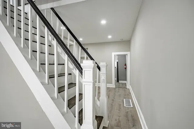 a view of staircase with wooden floor and white walls