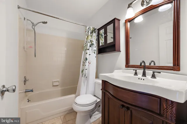 a bathroom with a sink a toilet a mirror a vanity and shower