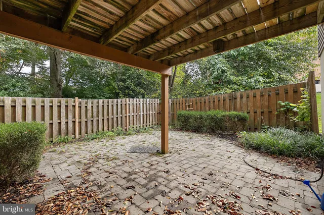 a view of a backyard with wooden fence and plants