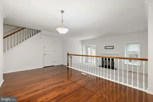 a view of staircase with wooden floor and white walls