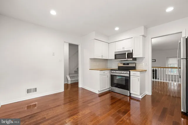 a kitchen with wooden floors and appliances