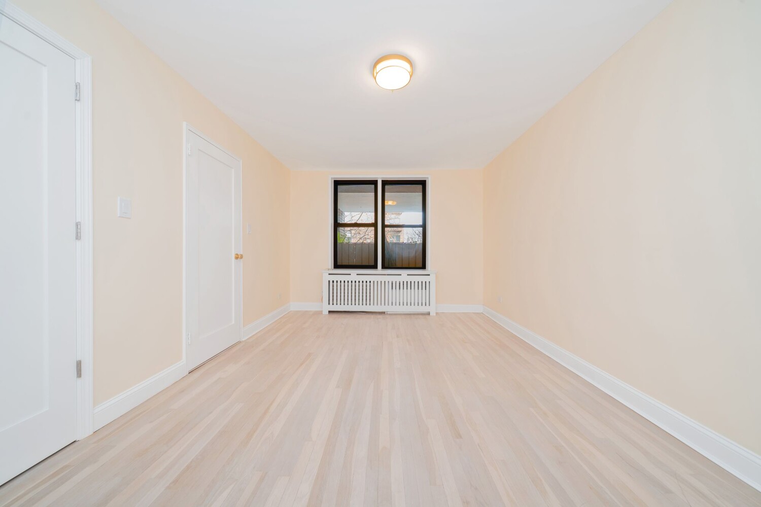 35-20 Leverich Street, Unit A403 Queens, NY 11372 - Photo 8 of 12 an empty room with wooden floor and windows