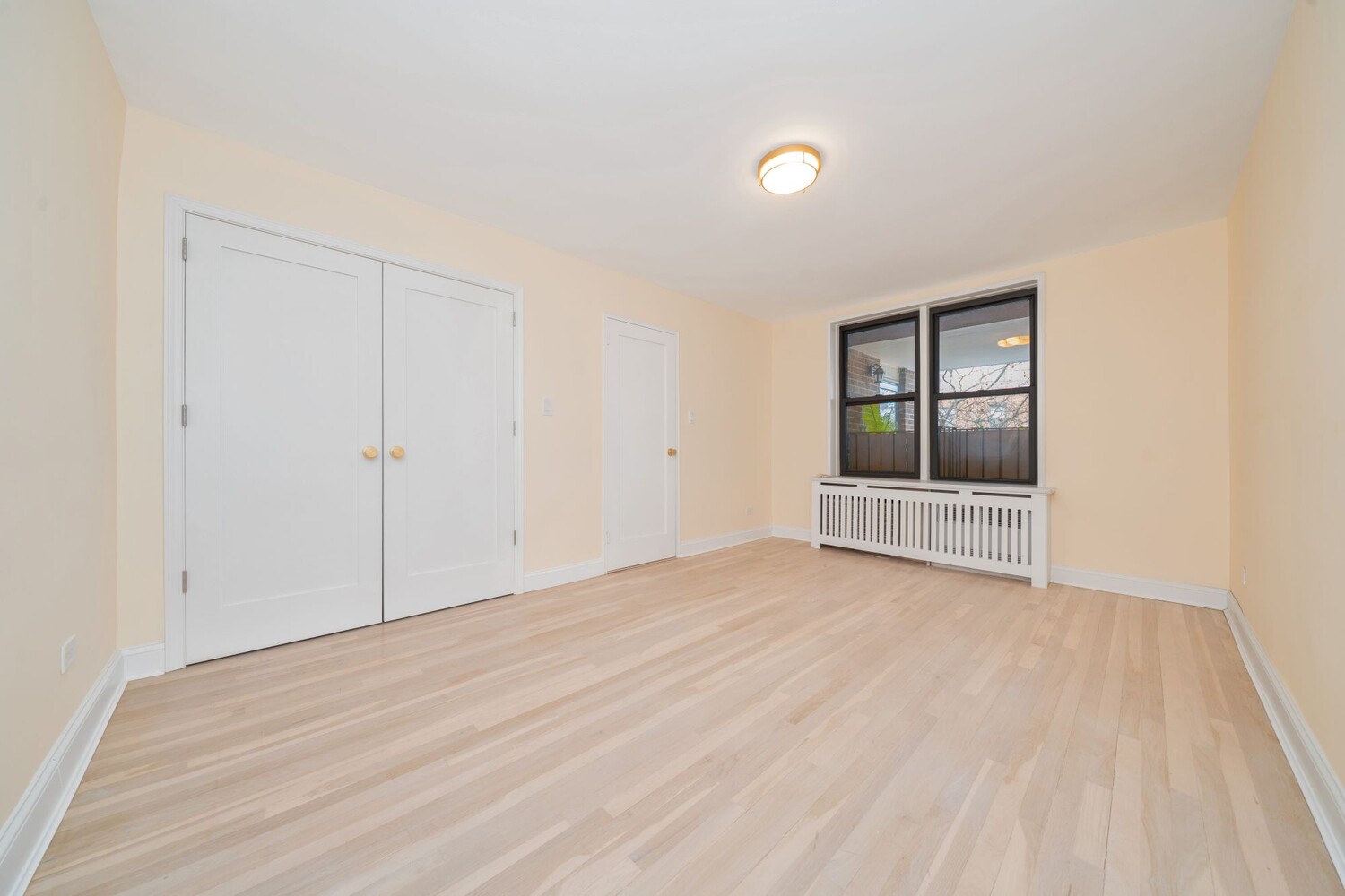 35-20 Leverich Street, Unit A403 Queens, NY 11372 - Photo 9 of 12 a view of an empty room with wooden floor and a window
