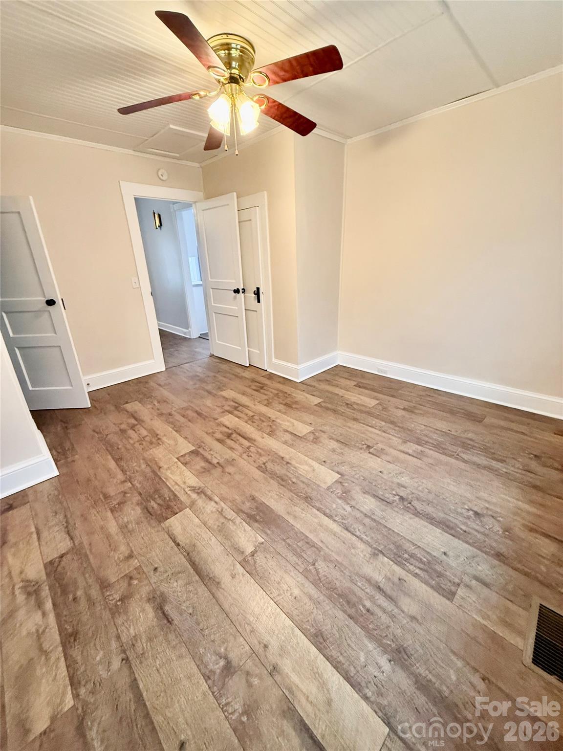 100 Perry Street Marion, NC 28752 - Photo 12 of 20 en empty room with wooden floor and ceiling fan