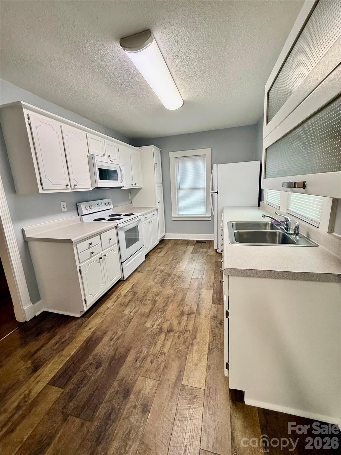 100 Perry Street Marion, NC 28752 - Photo 9 of 20 a kitchen with stainless steel appliances a stove a sink and white cabinets