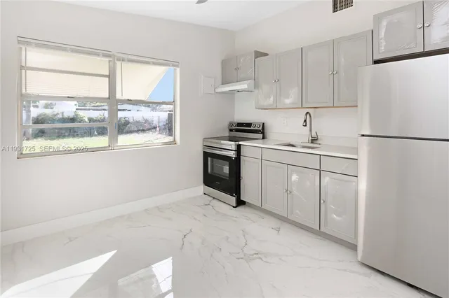 a kitchen with white cabinets and white appliances