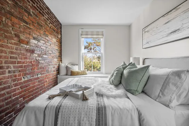 a bed sitting in a bedroom next to a lamp