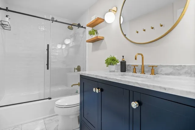 a bathroom with a sink a toilet and shower