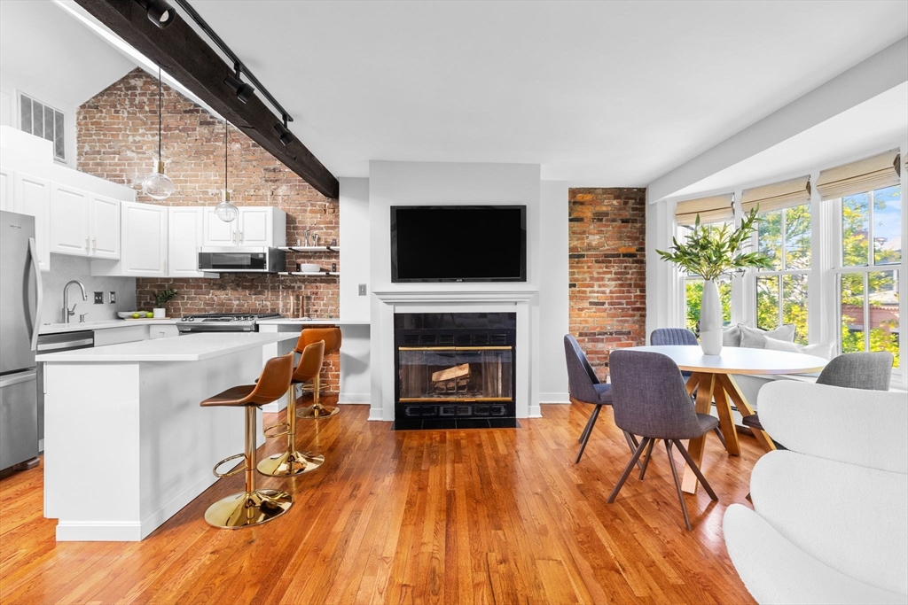 81 Waltham Street, Unit 6 Boston, MA 02118 - Photo 6 of 24 a living room with furniture a fireplace and a flat screen tv