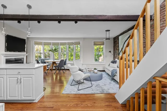 a living room with furniture a flat screen tv and a large window