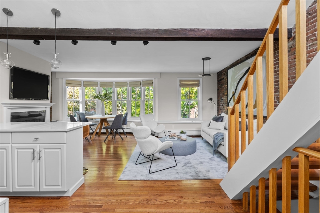 81 Waltham Street, Unit 6 Boston, MA 02118 - Photo 9 of 24 a living room with furniture a flat screen tv and a large window