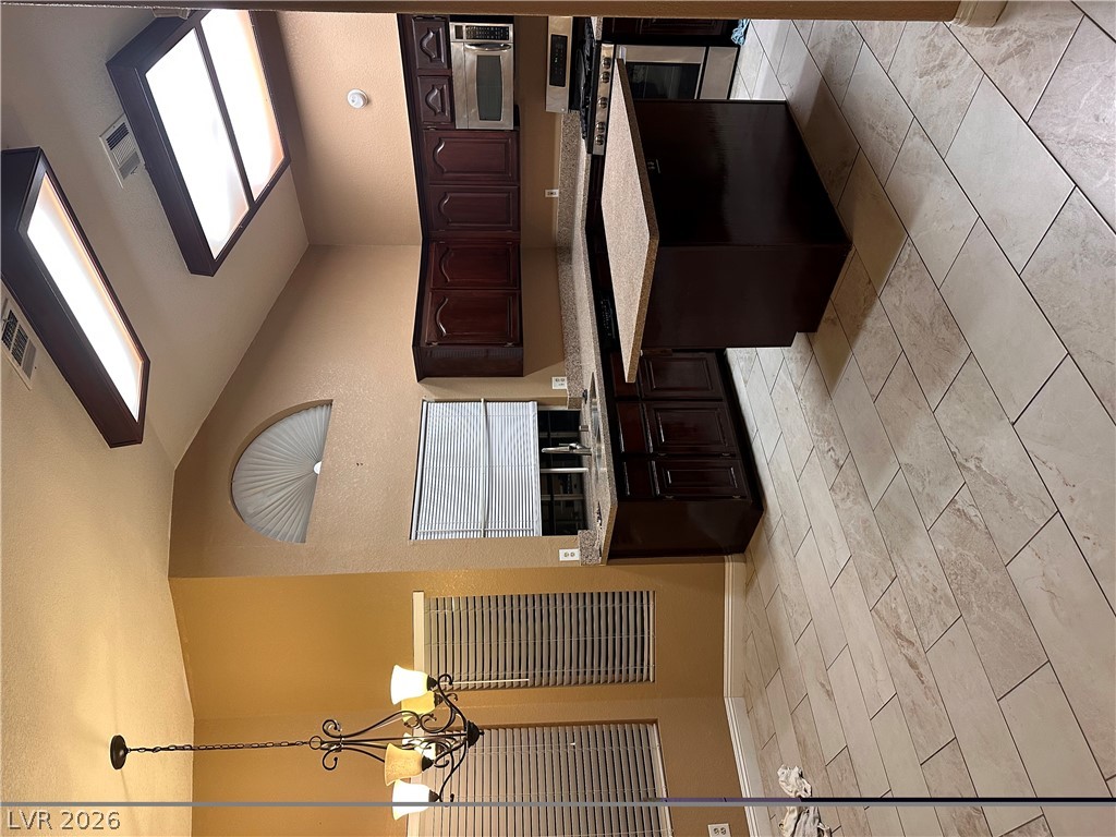 2600 Shakespeare Road Las Vegas, NV 89108 - Photo 4 of 6 An inviting kitchen with a central island and contemporary lighting fixtures.