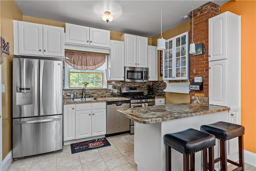 1701 Darlington Road Beaver Falls, PA 15010 - Photo 12 of 30 a kitchen with stainless steel appliances granite countertop a refrigerator sink stove microwave and cabinets