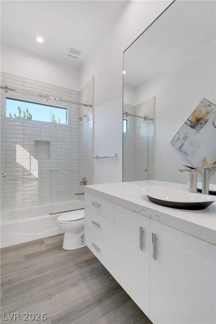 10 Ridge Blossom Road Las Vegas, NV 89135 - Photo 32 of 64 Bathroom featuring bath / shower combo with glass door, vanity, light wood-style floors, and recessed lighting
