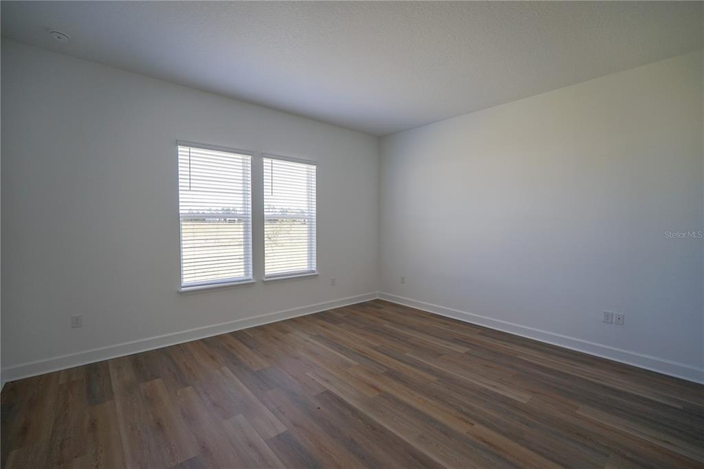 Undisclosed Address Palm Coast, FL 32137 - Photo 4 of 14 an empty room with wooden floor and windows