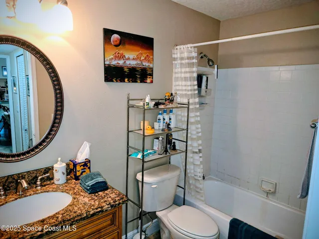 a bathroom with a granite countertop sink mirror vanity and toilet