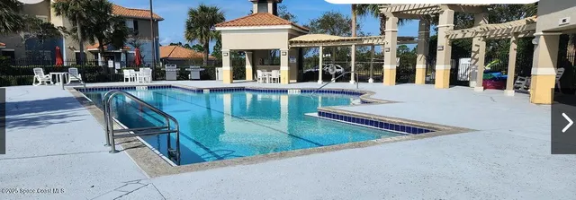 a view of a building with a patio and a yard