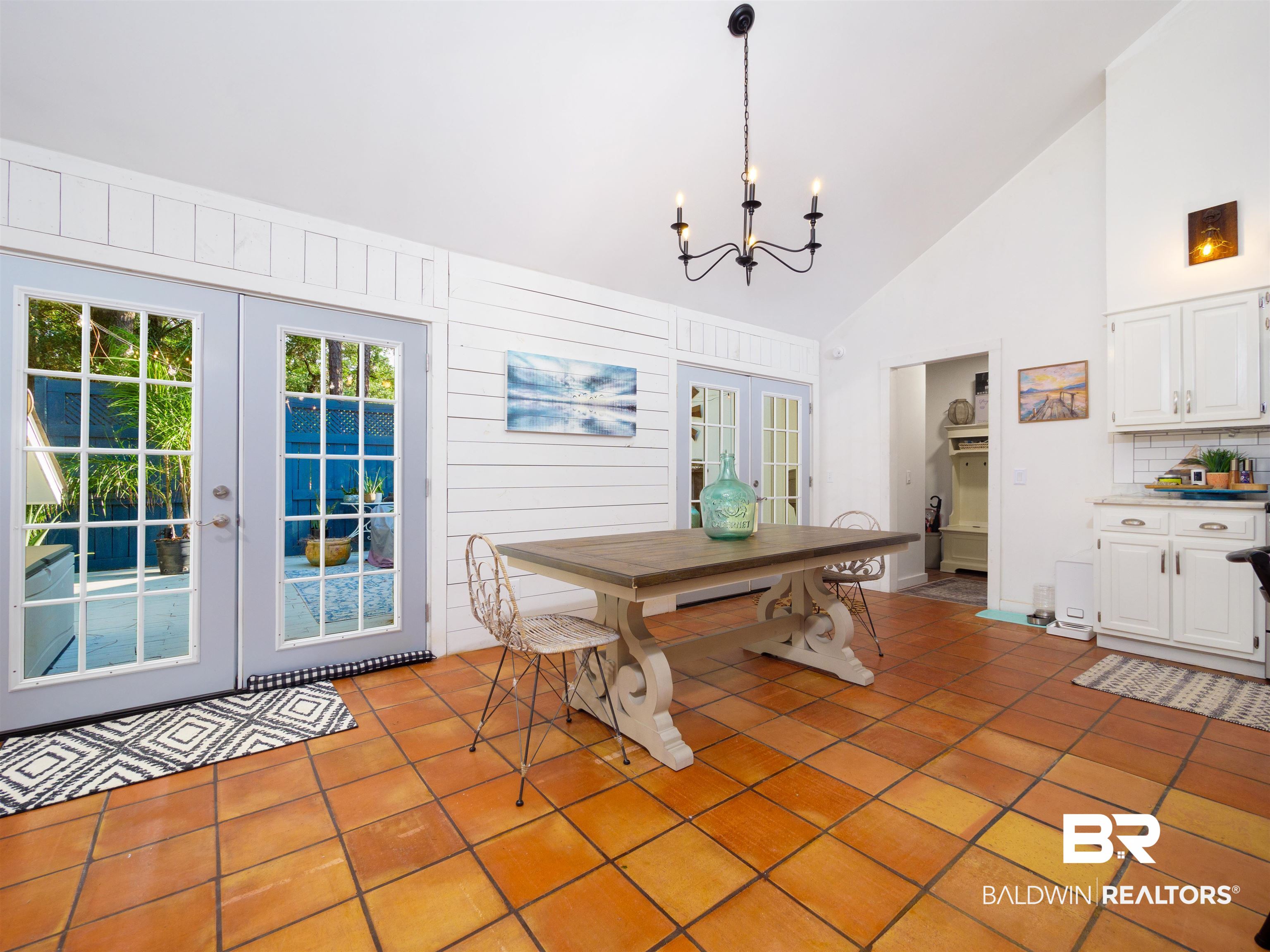 494 Ridgewood Drive Daphne, AL 36526 - Photo 10 of 40 Unfurnished dining area featuring wooden walls, french doors, high vaulted ceiling, and light tile patterned floors