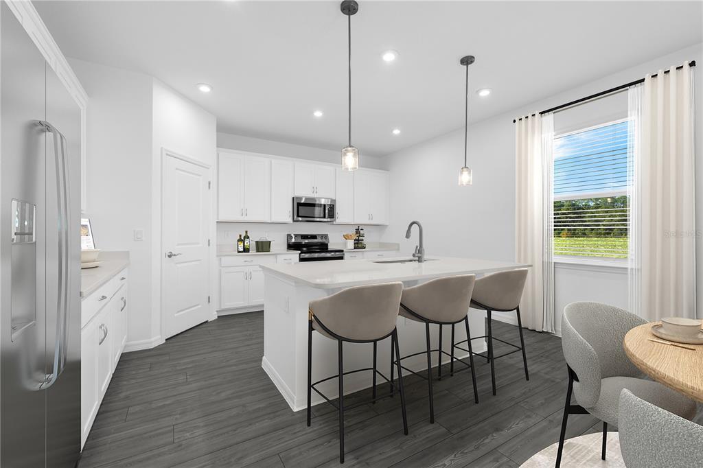 1873 Shadow Box Bend St. Cloud, FL 34771 - Photo 4 of 27 a kitchen with stainless steel appliances granite countertop a kitchen island hardwood floor and a sink