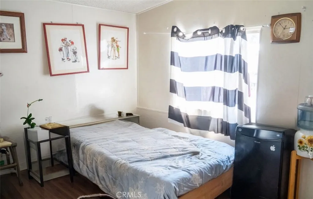7717 Church Street, Unit 54 Highland, CA 92346 - Photo 8 of 13 a bedroom with a bed and a table in it