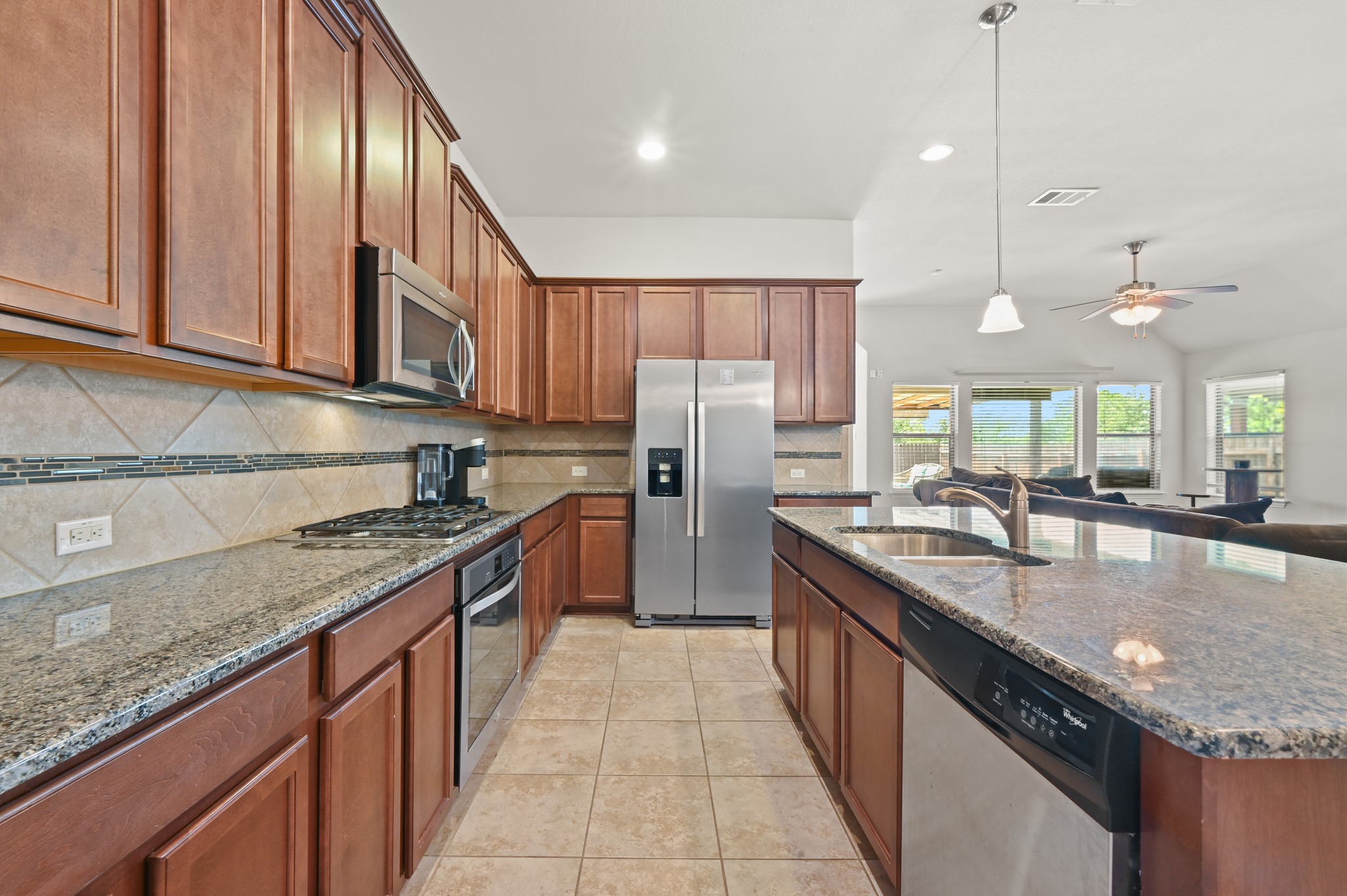 877 Hot Spring Valley Buda, TX 78610 - Photo 6 of 36 a large kitchen with stainless steel appliances granite countertop a sink a counter top space appliances and cabinets