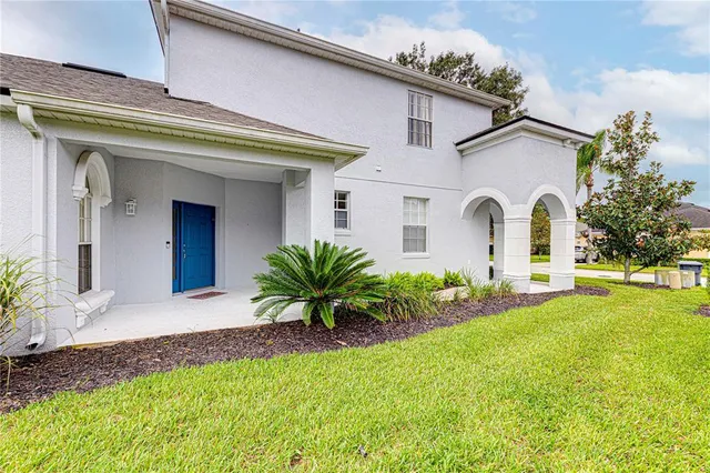 a front view of a house with a yard and potted plants
