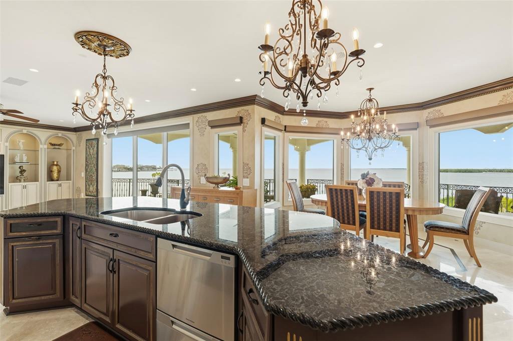 2115 Alexis Court Tarpon Springs, FL 34689 - Photo 23 of 100 a kitchen with a table chairs and chandelier