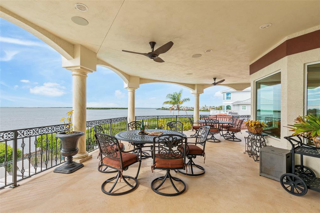 2115 Alexis Court Tarpon Springs, FL 34689 - Photo 27 of 100 a view of a patio with table and chairs potted plants with floor to ceiling window
