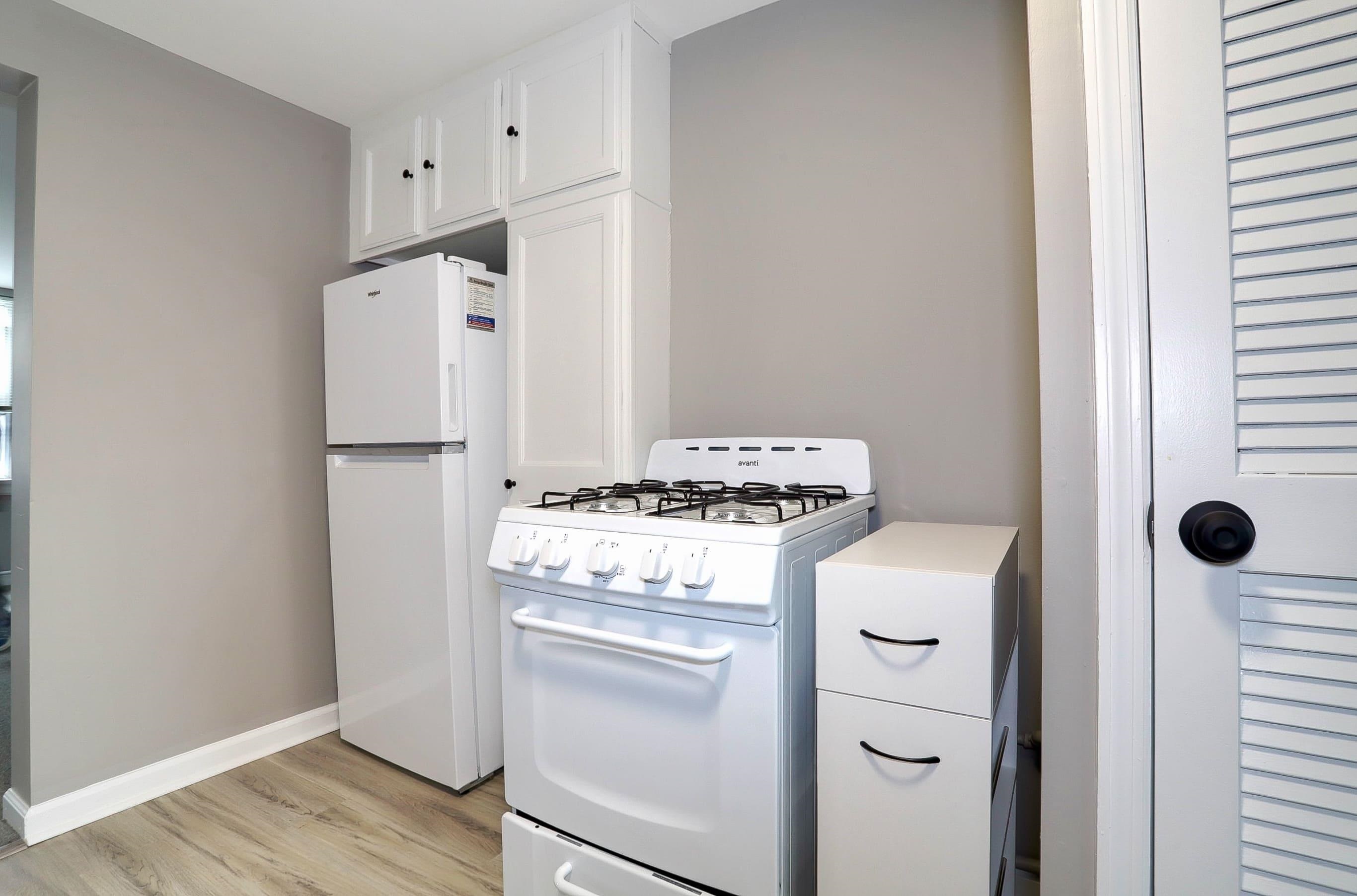 164 6th Street, Unit 2 Hoboken, NJ 07030 - Photo 9 of 12 a kitchen with a stove a refrigerator and white cabinets