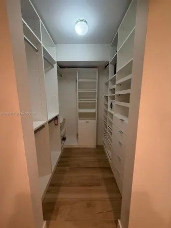 a view of walk in closet with empty racks